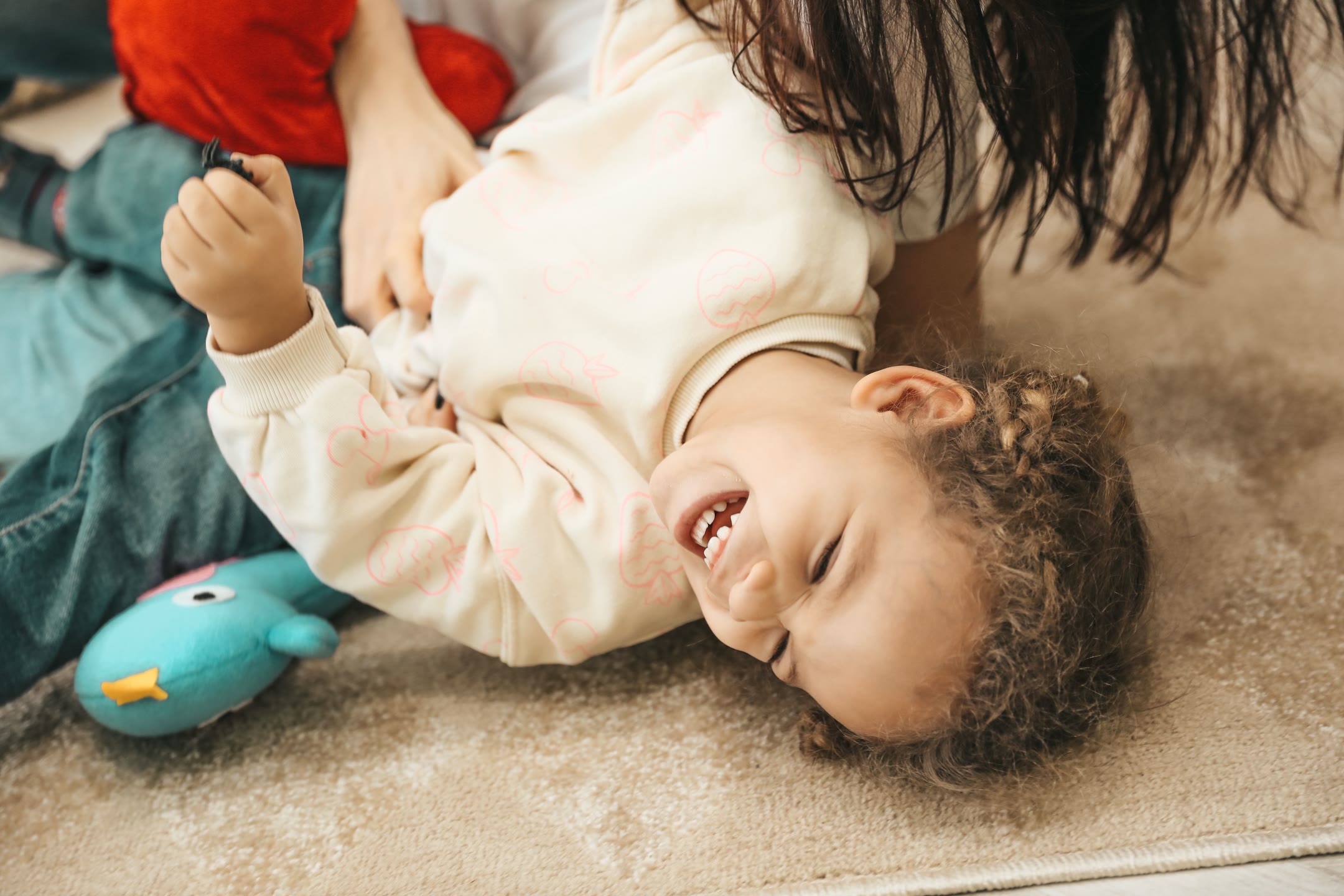 pexels-alina-rossoshanska-338724645-17022785-optimized A child who is laughing from being tickled